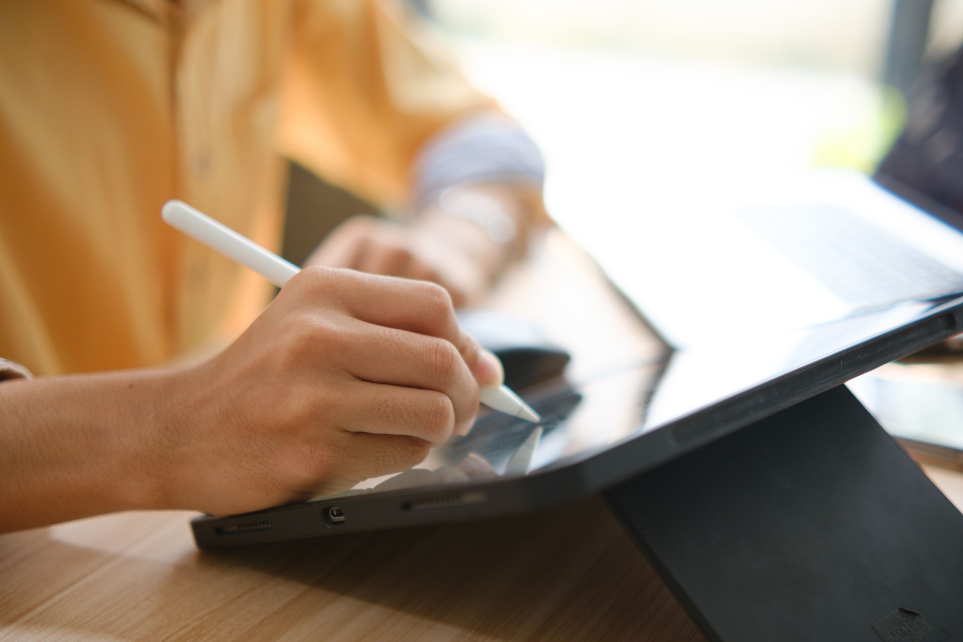 Male web designer drawing with graphic tablet at table in office.